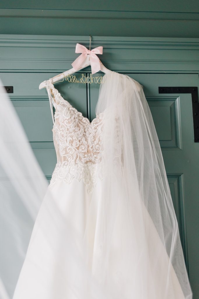 a bridal gown hanging from a door