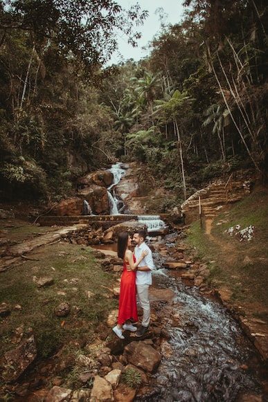  a couple posing in front of a waterfall